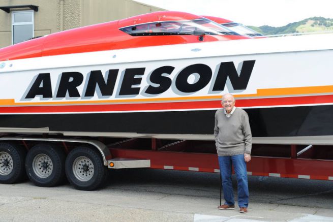 Howard Arneson devant un bateau de course offshore lors de ses 96 ans